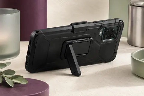 Étui noir pour Galaxy A12 avec clip ceinture pivotant et béquille intégrée, posé dans un décor minimaliste.