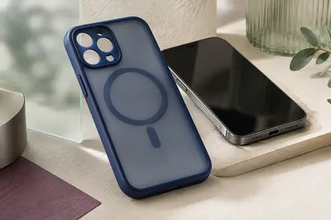 Coque bleu foncé au dos mat translucide et à l’anneau magnétique, près d’un smartphone sans marque.