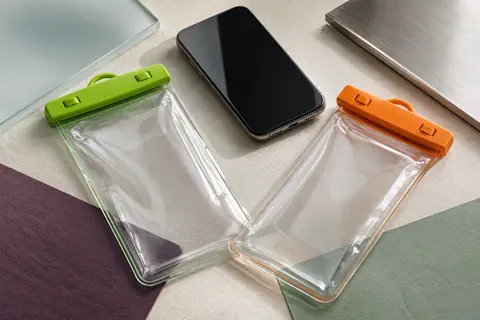 Deux pochettes étanches pour smartphone, aux accents verts et orange, près d’un téléphone sans marque.